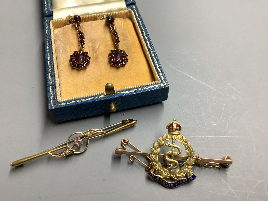 A 15ct gold amethyst and pearl-set bar brooch, gross 2.1 grams, an RAMC 9ct gold and enamel military sweetheart brooch and a pair of 9ct gold and garnet drop earrings